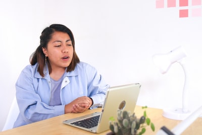 穿蓝色衬衫的女士使用macbook air